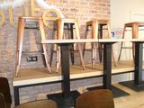 several chairs and tables in a room with a brick wall behind them