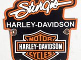 une enseigne Harley-Davidson noire et orange sur le côté d'un camion blanc