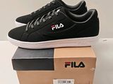 des chaussures de tennis Fila noires et blanches posées sur une boîte