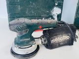 a corded sander and a tool case on a table
