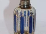 a silver and blue glass bottle on a white surface