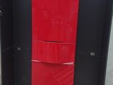 a red refrigerator sitting on a pallet in a room