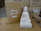 une statue représentant un Bouddha assis sur une boîte