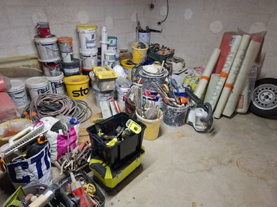 Il y a de nombreux types de peinture et d'outils dans ce garage