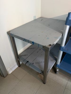 une table en métal avec une chaise bleue à côté