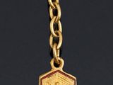 an image of a gold plated necklace with a red rose on it