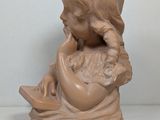 a small statue of a girl sitting on a table