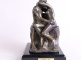 statue représentant un homme assis sur un rocher, les mains sur le visage