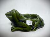 an image of a green frog figurine sitting on a white surface