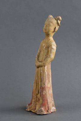 une vieille statue représentant une femme avec un oiseau sur l'épaule