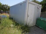 a white portable toilet sitting in the middle of a field
