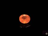 an orange moon in the dark sky with a reflection on the ground