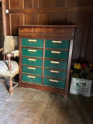 une commode verte posée à côté d'une chaise dans une pièce