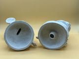 pair of white porcelain vases on a table with a yellow background
