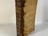 an old book sitting on top of a table next to a white wall