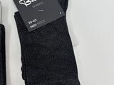 two pairs of men ' s black socks on a white surface