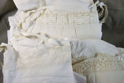 une pile de vêtements blancs posée sur un lit