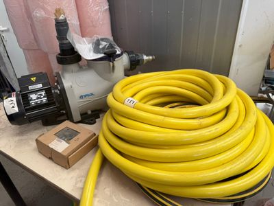 un tuyau jaune posé sur une table, à côté d'une pompe