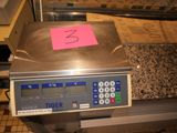 a scale with a pink sticker on it sitting on a counter