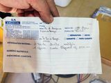 a person holding a piece of paper with writing on it