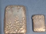 two silver lighters sitting on a blue surface