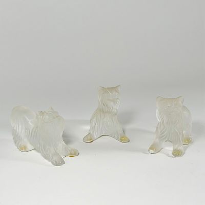 three glass figurines of a dog and a cat on a white surface