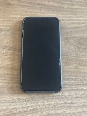 une coque noire d'iPhone posée sur une table en bois