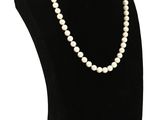 un collier de perles blanches sur un mannequin noir
