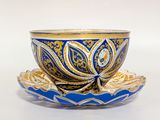 tasse à thé et soucoupe bleues et dorées posées sur une soucoupe