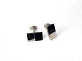 two black and silver cufflinks with a square design on them