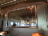 le reflet d'une personne dans un miroir accroché au mur