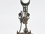 une horloge posée sur un socle, sur fond blanc