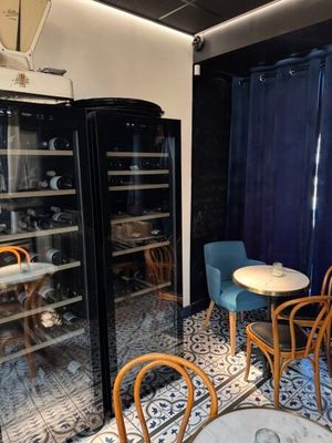 des tables et des chaises dans une pièce dotée d'une porte vitrée et de rideaux bleus