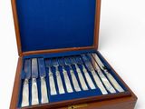 a wooden box with silverware in it on a white surface