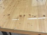 the table is made of wood and has a glass top