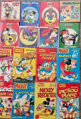 many mickey mouse books are stacked on the floor
