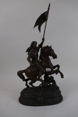 bronze statue of a man on a horse holding a flag