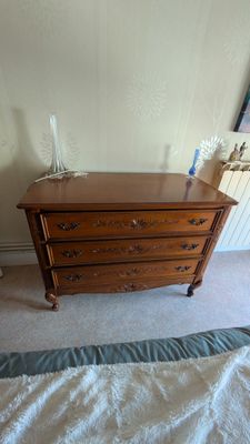 une commode en bois dans un coin d'une chambre