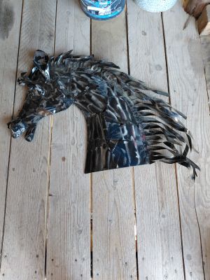 a horse head made out of metal on a wooden floor