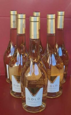 six bottles of wine are lined up on a red table