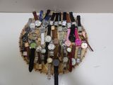 de nombreuses montres posées sur un plateau en bois