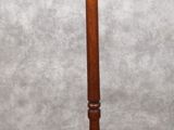 une image représentant un porte-manteau en bois surmonté de deux bougies