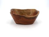 a wooden bowl that is sitting on a white surface