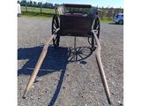 a horse drawn carriage that is sitting in the gravel