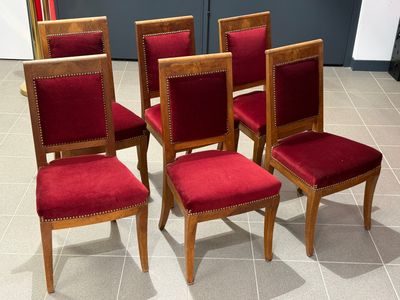 four chairs with red velvet upholstered seats sit on a tile floor