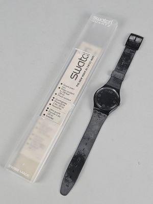 an image of a watch sitting on top of a table next to a package