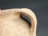 a hand that is holding a clay vase
