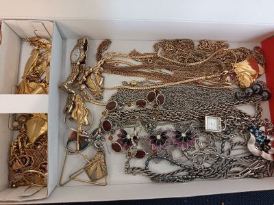 a box full of gold and silver jewelry on a table