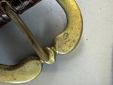 a close up of a brown belt with a metal buckle