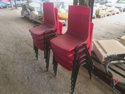 trois chaises rouges placées les unes à côté des autres dans un entrepôt